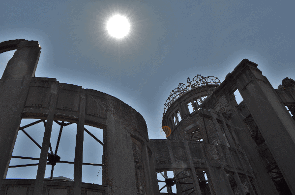 The darkened A-Bomb dome in Hiroshima with the sun shining overhead