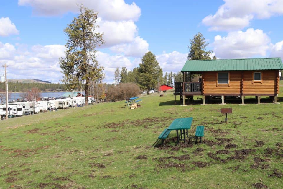 A cabin in a grassy area near an RV park