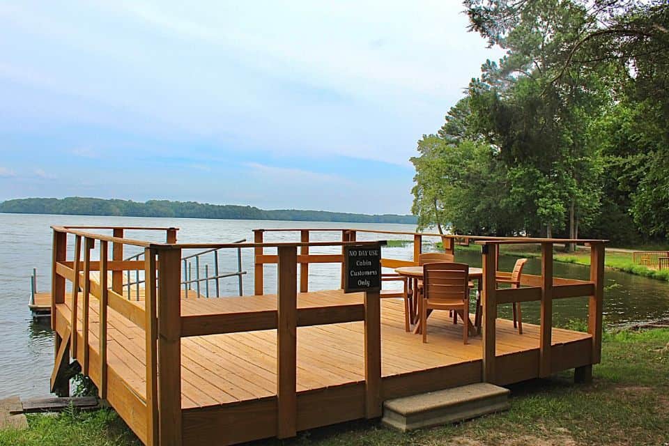 A wooden boat dock with a table and chairs