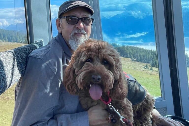 a man with a service dog on his lap