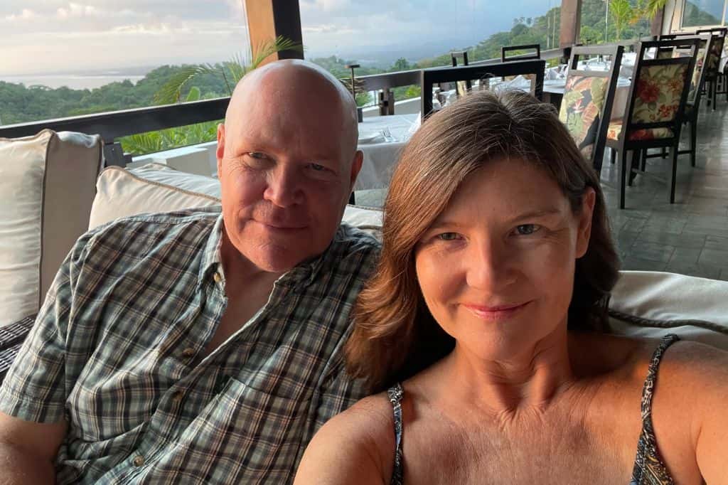 A man and a woman taking a selfie at an open-air restaurant