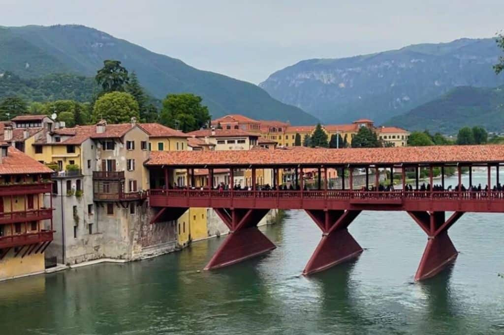 A covered red bridge across a river