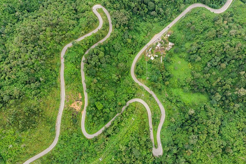 Aerial view of a winding highway through green landscape