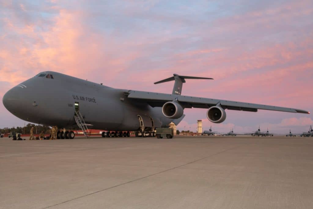 a large military aircraft on the flight line at dusk