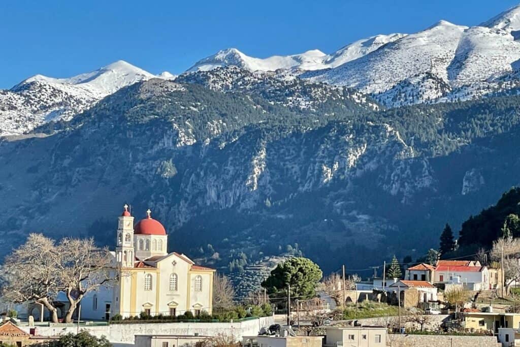 snow-covered mountains surround a town on crete