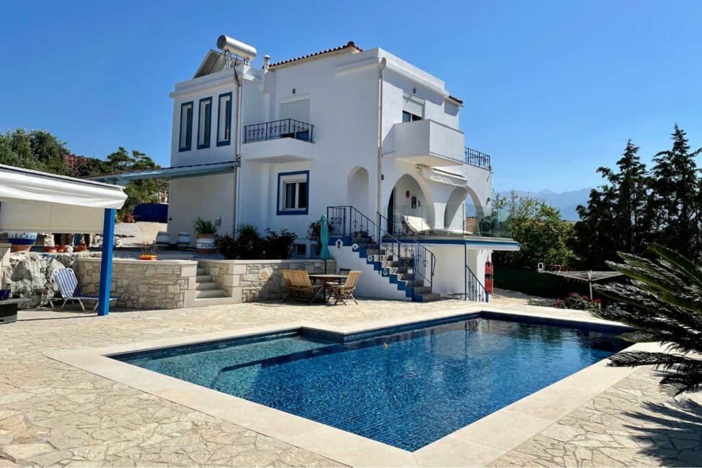 A large white villa next to a pool