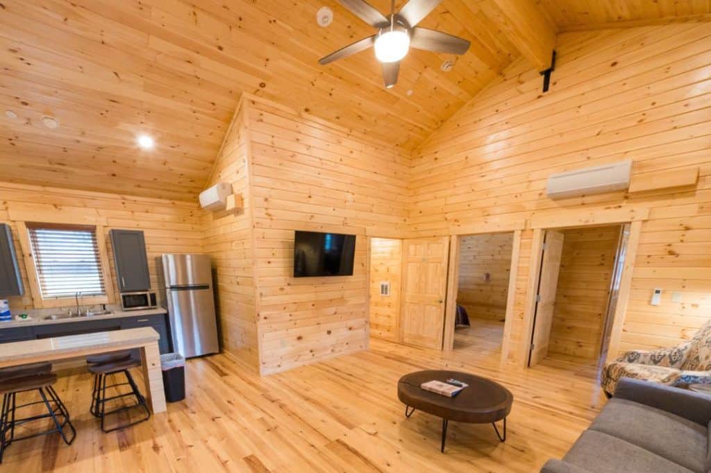 the inside of a large wooden cabin with full kitchen and living room