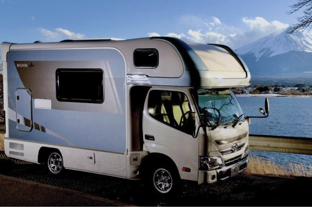 A campervan parked by a lake with Mt Fuji in the background