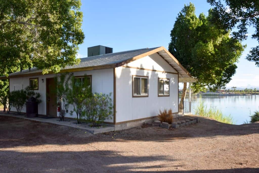 A white wooden cabin on a lake